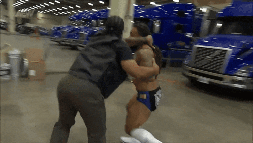 a man is wrestling another man in front of a sign that says aew