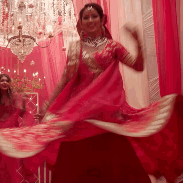 a woman in a red dress is dancing in front of a mirror