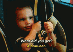 a child in a car seat is holding a bow and arrow and asking what did you get a bow-ner