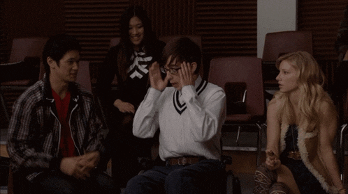 a group of people are sitting in chairs and one of them has glasses on