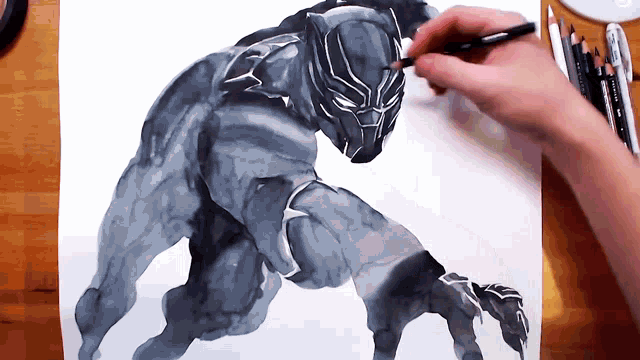 a person is drawing a black panther with a pencil on a piece of paper