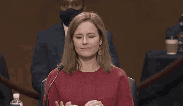 a woman in a red shirt is holding up a drawing of a penis
