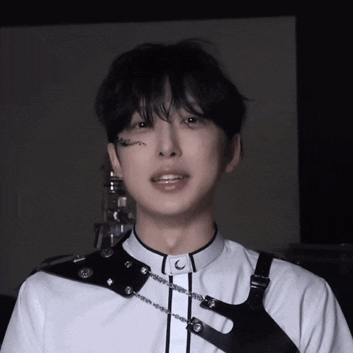 a close up of a person wearing a white shirt and a black harness