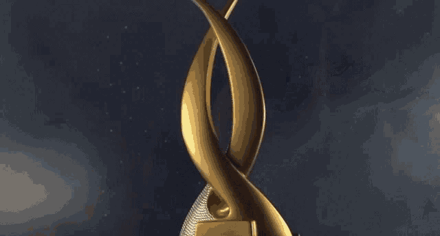 a gold sculpture with a microphone in the center