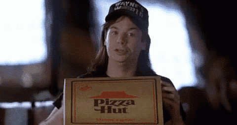 a woman is holding a pizza hut box in her hand .