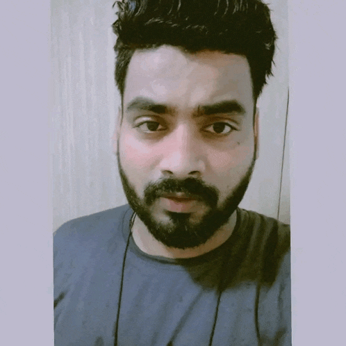 a man with a beard is wearing headphones and a blue shirt