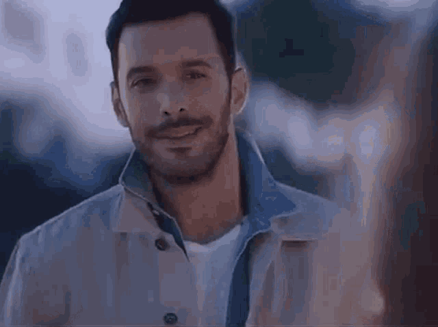 a man with a beard is smiling while looking at a woman .