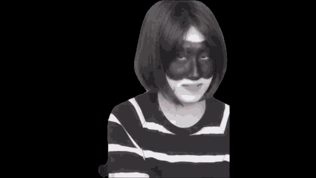 a person wearing a black and white striped shirt and a black mask