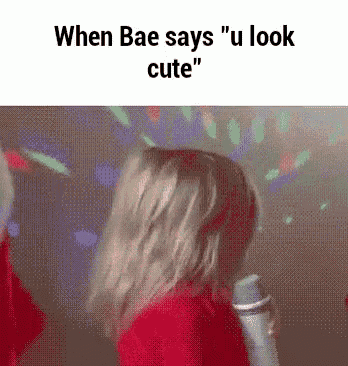 a girl in a red jacket is dancing in front of a microphone and says `` when bae says u look cute ''
