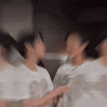 a blurry picture of a group of people standing next to each other in a room .