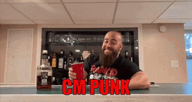a man with a beard holds a red cup and a bottle of jack daniel 's whiskey