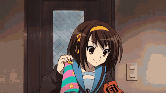 a girl in a school uniform is holding a striped hat and a red badge with the letter d on it