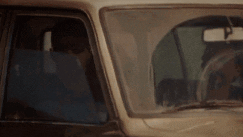 a man is driving a car with a woman in the back seat .