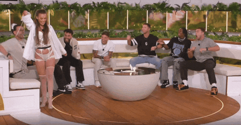 a group of people are sitting around a table with one wearing a shirt that says ' a ' on it