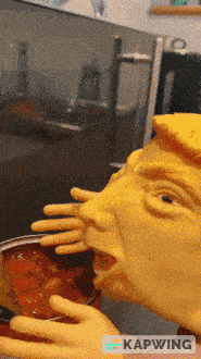a statue of donald trump eating a bowl of soup