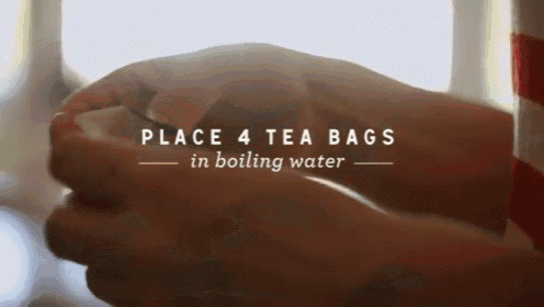 a person is holding a cup of tea and the words place 4 tea bags in boiling water