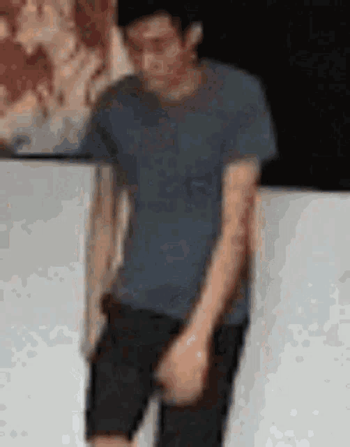 a blurry picture of a man in a gray shirt and black shorts