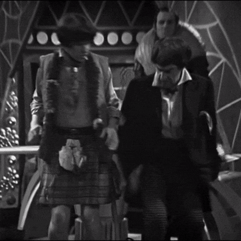 a man in a suit and tie is standing next to a woman in a plaid skirt