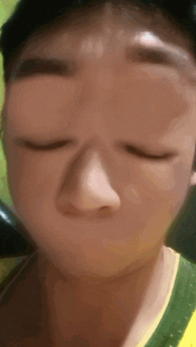 a close up of a person making a funny face with their eyes closed