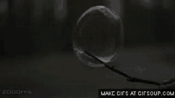 a person is blowing a soap bubble on a stick .