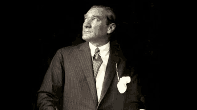 a man in a suit and tie is looking up at something .