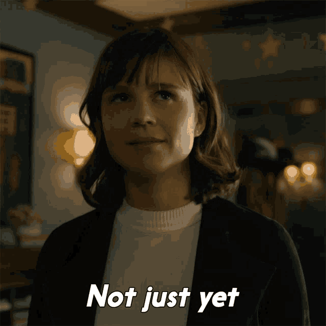 a woman says " not just yet " in front of her