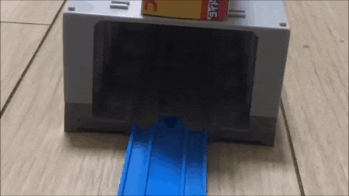 a toy train is going through a tunnel with a box on top of it that says ' tc ' on it