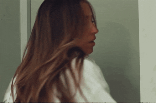 a woman 's hair is blowing in the wind in a blurry photo
