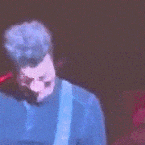 a blurry picture of a man playing a guitar on a stage .