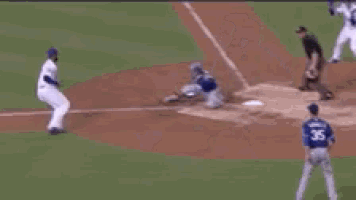 a group of baseball players are standing on a field fighting each other .