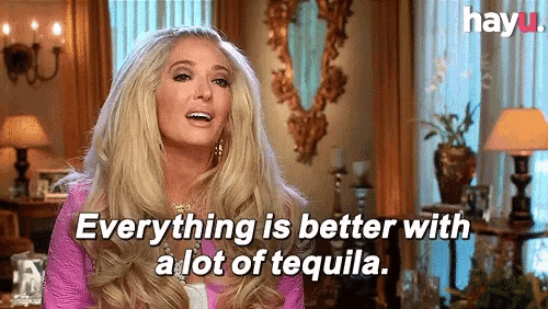 a blonde woman is sitting in a living room and says " everything is better with a lot of tequila "
