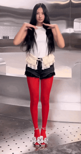 a woman wearing red tights and shorts is standing on a metal floor