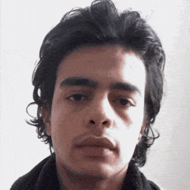 a close up of a man 's face with long hair