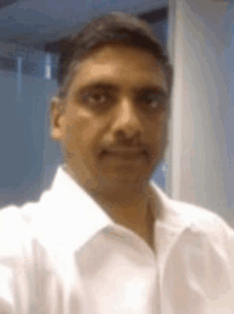 a man wearing a white shirt takes a selfie