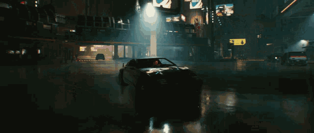 a car is driving down a wet street at night with a sign that says ' a ' on it