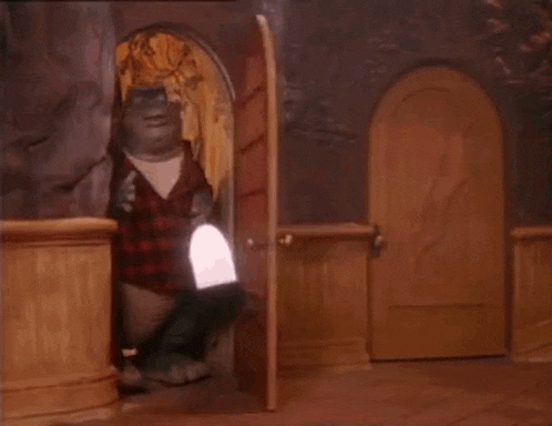 a dinosaur is standing in a doorway holding a lamp .