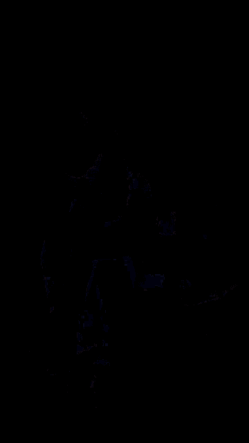 a man in a long black coat is dancing in a room