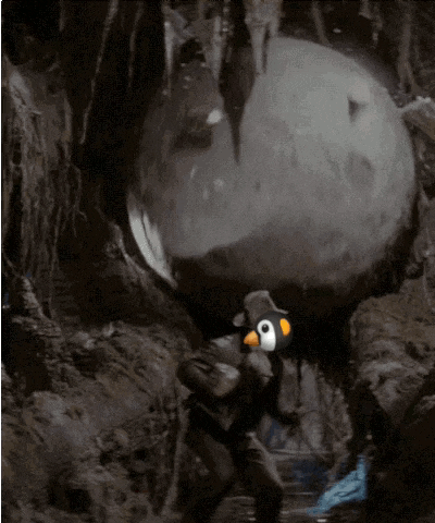 a man in a penguin costume is carrying a giant rock
