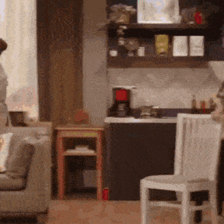 a living room with a couch and chairs and a kitchen with a coffee maker