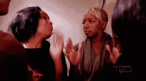 a group of women are standing next to each other and having a conversation .