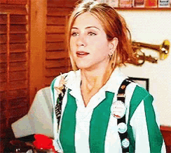 a woman is wearing a green and white striped shirt with buttons on it .