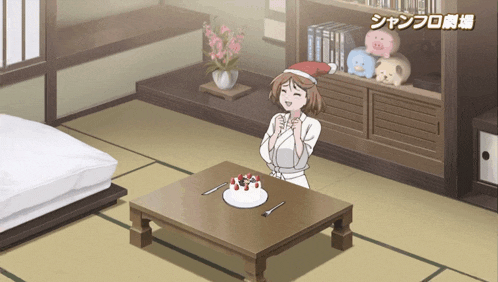 a woman in a santa hat stands next to a cake on a table