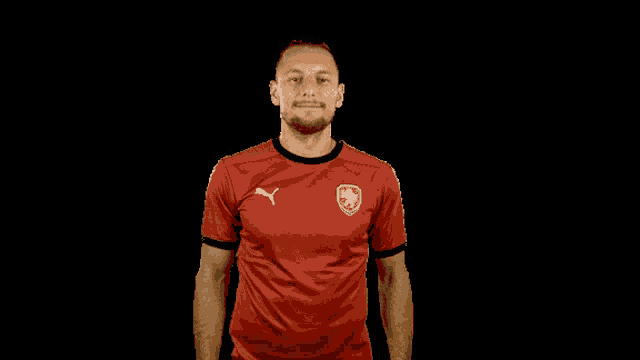a man wearing a red puma shirt with a lion on the front
