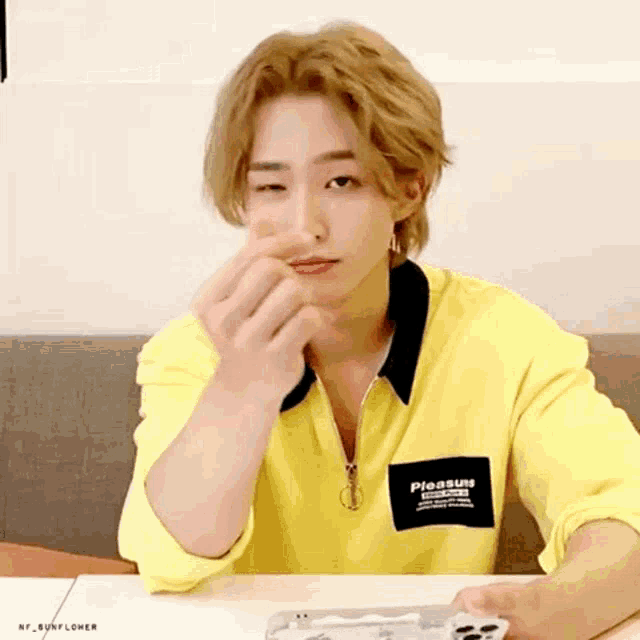 a young man wearing a yellow shirt with pleasure written on it
