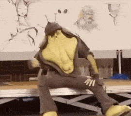 a cartoon character is sitting on a stage in front of a drawing of a woman
