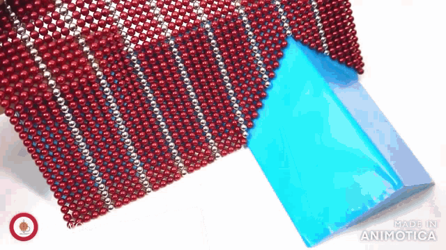 a red and white striped fabric made of beads and a blue item