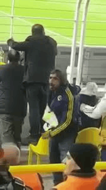 a group of people are sitting in a stadium watching a soccer match .