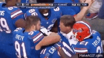a group of football players are hugging each other .