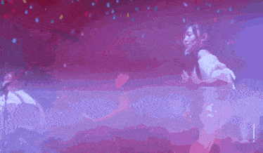 a purple and red background with a person standing in the foreground