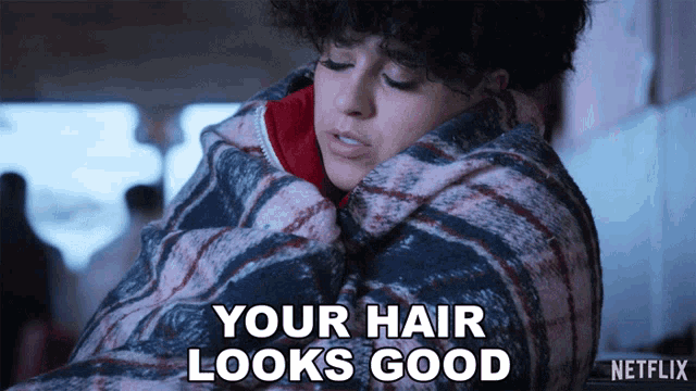a woman is wrapped in a plaid blanket and says your hair looks good